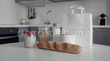 厨房木制桌子上有面包、燕<strong>麦片</strong>、荞麦、牛奶、蔬菜的未<strong>包装</strong>购物袋。 零垃圾家庭和